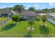 Large backyard featuring lush green grass, shade trees, and a covered patio area at 4229 Settlers Ct, St Cloud, FL 34772