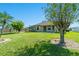 Large backyard features lush green grass, shade trees, and a covered patio area at 4229 Settlers Ct, St Cloud, FL 34772