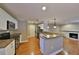 Open kitchen with stainless appliances, breakfast bar, and cozy living area with fireplace at 426 S Lakemont Ave, Winter Park, FL 32792