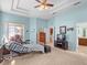 Spacious light blue bedroom with a tray ceiling, ceiling fan, two windows and an ensuite bathroom at 4918 Oakway Dr, St Cloud, FL 34771
