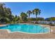 A large, fenced community pool is surrounded by chairs and mature trees and overlooks a lake at 4918 Oakway Dr, St Cloud, FL 34771