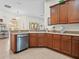 Kitchen with stainless steel dishwasher, wooden cabinets, tile floors, and a garden view at 4918 Oakway Dr, St Cloud, FL 34771