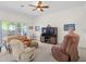 Spacious living room featuring cozy furniture, ceiling fan, and large windows providing ample natural light at 4918 Oakway Dr, St Cloud, FL 34771