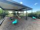 Playground with cushioned mulch ground, covered roof, and a black fence surrounding the entire area at 4918 Oakway Dr, St Cloud, FL 34771