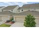 An aerial view of a well-maintained townhome community, featuring garages and manicured landscaping at 5892 Soter Ln, Windermere, FL 34786