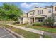 Tan two-story townhome with a sidewalk and blue sky on a sunny day at 5892 Soter Ln, Windermere, FL 34786