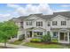Attractive two-story townhome featuring a cozy front porch and lush landscaping at 5892 Soter Ln, Windermere, FL 34786