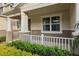 Inviting front porch with white railing, landscaped greenery, and covered entryway at 5892 Soter Ln, Windermere, FL 34786