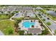 Aerial view of a community pool with brick surround, lounge chairs, shade covers, and manicured landscaping at 5892 Soter Ln, Windermere, FL 34786