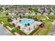 Aerial view of a community pool with brick surround, lounge chairs, shade covers, and manicured landscaping at 5892 Soter Ln, Windermere, FL 34786