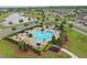 Aerial view of a community pool with brick surround, lounge chairs, shade covers, and manicured landscaping at 5892 Soter Ln, Windermere, FL 34786