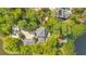 Aerial view of luxury estate with a private dock on the lake, surrounded by lush greenery at 6082 Twin Lakes Dr, Oviedo, FL 32765
