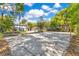 Spacious sand volleyball court in the backyard of a well-maintained home surrounded by lush greenery and trees at 6082 Twin Lakes Dr, Oviedo, FL 32765