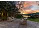 Backyard featuring comfortable seating and picturesque views of the lake and lush landscaping at sunset at 6082 Twin Lakes Dr, Oviedo, FL 32765