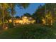 Beautiful backyard at dusk featuring a well-manicured lawn, patio with seating, and inviting string lights at 6082 Twin Lakes Dr, Oviedo, FL 32765