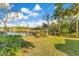 Tranquil backyard featuring a covered dock, lush lawn and tropical landscaping on a waterfront property at 6082 Twin Lakes Dr, Oviedo, FL 32765