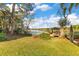 A lush backyard featuring a gazebo on the water, mature trees, and manicured lawn at 6082 Twin Lakes Dr, Oviedo, FL 32765