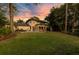 Spacious backyard with a lush lawn, mature trees, and a large patio area ideal for outdoor entertaining at 6082 Twin Lakes Dr, Oviedo, FL 32765