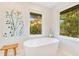 Spa-like bathroom with sleek soaking tub, natural light, and views of the outdoors at 6082 Twin Lakes Dr, Oviedo, FL 32765