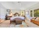 Inviting bedroom with large windows, a woven headboard, decorative rug, and a cozy reading nook at 6082 Twin Lakes Dr, Oviedo, FL 32765