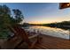 Relaxing waterfront living featuring a wooden dock with Adirondack chairs overlooking the serene lake at sunset at 6082 Twin Lakes Dr, Oviedo, FL 32765