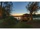 Waterfront property featuring a covered dock and a tranquil lake setting at dusk at 6082 Twin Lakes Dr, Oviedo, FL 32765