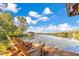 Lakeside wooden dock with lounge chairs overlooking the lake, lily pads, and distant shoreline at 6082 Twin Lakes Dr, Oviedo, FL 32765