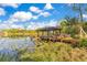 Waterfront property featuring a covered dock on a scenic lake with lily pads and lush vegetation at 6082 Twin Lakes Dr, Oviedo, FL 32765