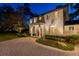 Charming two-story home with a circular brick driveway and lush landscaping, illuminated at night at 6082 Twin Lakes Dr, Oviedo, FL 32765