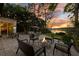 Inviting patio area with comfortable seating, a fire pit, and scenic views of the lake at sunset at 6082 Twin Lakes Dr, Oviedo, FL 32765