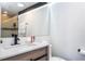 Modern bathroom features a sleek vanity, black hardware, and well-lit mirror in neutral tones at 6165 Carrier Dr # 3602, Orlando, FL 32819