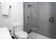 Modern bathroom features gray tiled shower with glass enclosure, toilet and white vanity at 6165 Carrier Dr # 3602, Orlando, FL 32819