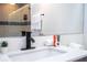 Bathroom featuring a bright quartz countertop, modern black hardware, and tiled shower reflected in the mirror at 6165 Carrier Dr # 3602, Orlando, FL 32819