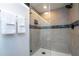 Tiled shower with neutral walls, black trim and hardware, and glass door creates a modern, bright bathroom design at 6165 Carrier Dr # 3602, Orlando, FL 32819