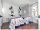 Bright bedroom with two twin beds, Disney themed decor and geometric accent wall at 6165 Carrier Dr # 3602, Orlando, FL 32819
