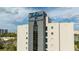 Exterior shot of 'The Enclave Hotel & Suites' building, with visible signage against a partly cloudy sky at 6165 Carrier Dr # 3602, Orlando, FL 32819