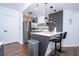 Well-lit modern kitchen with stainless steel appliances, bar seating, and dark wood-look floors at 6165 Carrier Dr # 3602, Orlando, FL 32819