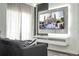Chic living room with mounted television and adjacent large window offering plenty of natural light at 6165 Carrier Dr # 3602, Orlando, FL 32819