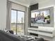 Living room featuring a flat screen TV, modern decor and an outdoor view from the balcony at 6165 Carrier Dr # 3602, Orlando, FL 32819
