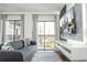Bright living room featuring a flat screen TV, modern decor and an outdoor view at 6165 Carrier Dr # 3602, Orlando, FL 32819