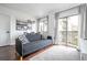 Cozy living room with hardwood floors, modern sofa, and sliding doors to a balcony at 6165 Carrier Dr # 3602, Orlando, FL 32819