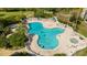 An aerial view of an outdoor swimming pool with lounge chairs and people enjoying the water at 6165 Carrier Dr # 3602, Orlando, FL 32819