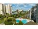 A scenic view of the inviting pool area surrounded by lush tropical landscaping and buildings on a sunny day at 6165 Carrier Dr # 3602, Orlando, FL 32819