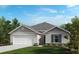 Charming single-story home with a two-car garage, well-manicured lawn, and colorful landscaping at 648 Royal Palm Dr, Dundee, FL 33838