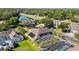 A landscape view showcasing a home near a pond with an enclosed pool, surrounded by lush greenery and other homes at 6761 Scimitar Ave, Orlando, FL 32812
