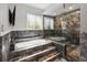 Modern bathroom with a luxurious soaking tub, a glass-enclosed shower, and elegant marble tiling at 6761 Scimitar Ave, Orlando, FL 32812