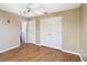 Bedroom features wood-look flooring, ceiling fan, closet space, and two white doors to other spaces at 6761 Scimitar Ave, Orlando, FL 32812