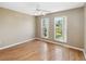 Sunlit bedroom featuring wood-look flooring, a white ceiling fan and beautiful green views from the windows at 6761 Scimitar Ave, Orlando, FL 32812