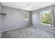 Carpeted bedroom with neutral gray walls and two windows offering natural light and outdoor views at 6761 Scimitar Ave, Orlando, FL 32812