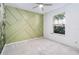 Light bedroom with a unique panel wall and view of the landscape through the window at 6761 Scimitar Ave, Orlando, FL 32812